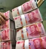 An employee arranges yuan notes at a branch of the China Minsheng Bank in Nanjing, capital of east China's Jiangsu province April 28, 2006. China raised interest rates for the first time in 18 months on Thursday, sending ripples through surprised world markets who saw the move as an attempt to prevent the emerging economic powerhouse from overheating. REUTERS/Stringer